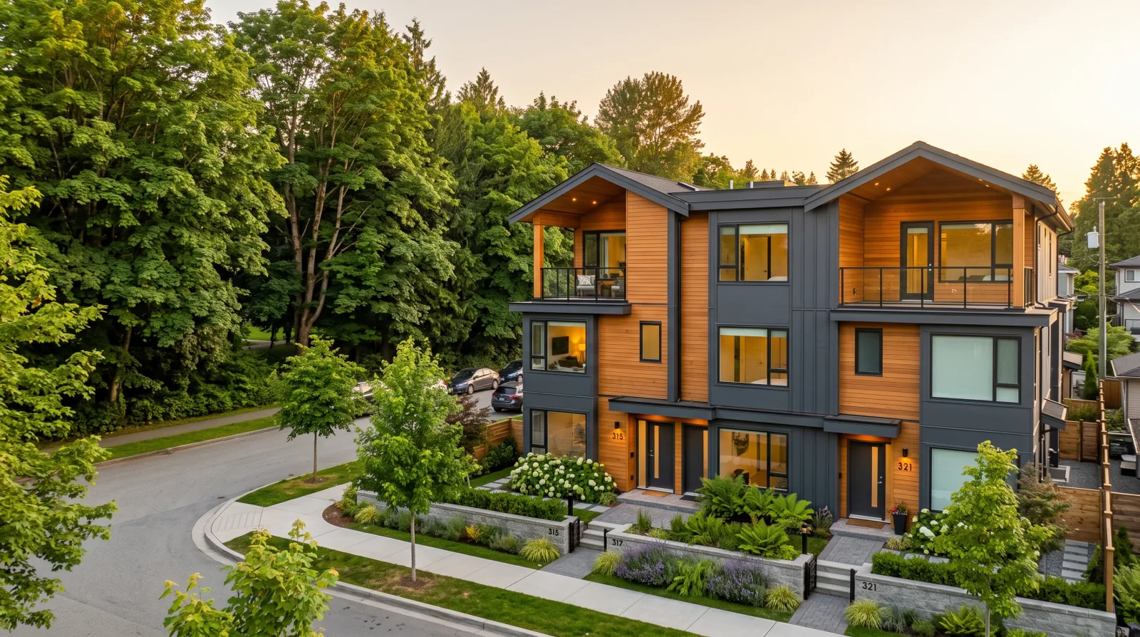 A new three-storey multiplex on a residential street beside Mahon Park in the City of North Vancouver, with mature park trees behind